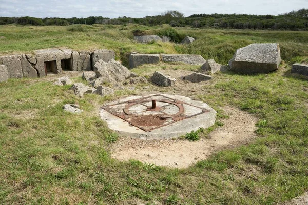 Çimenler ve çalılıklarla çevrili kraterlerin arasında Alman silah mevzilerinin kalıntıları. Pointe du Hoc, Fransa, 3 Temmuz 2023. 