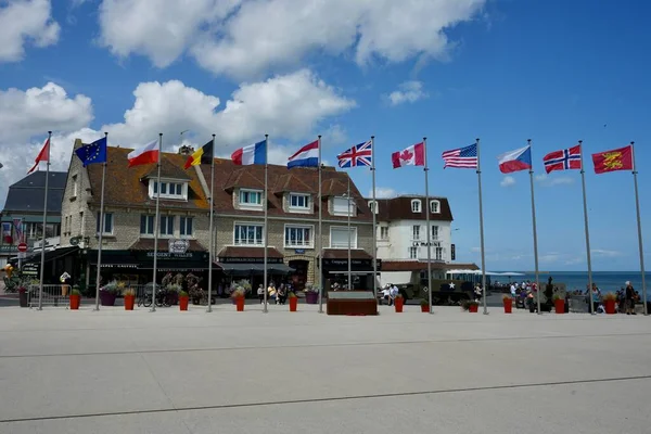 stock image National Flags in The Town Centre Square, with a US Army WW2 Half Track. Arromanches-les-Bains, France, July 6, 2023. 