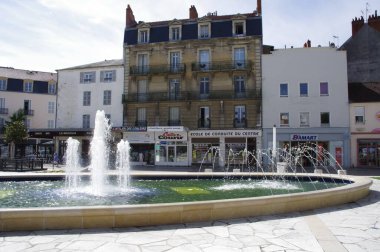 Charles de Gaulle Meydanı 'ndaki çeşmelerin arkasında dükkanlar var. Vichy, Fransa, 16 Ağustos 2012. 