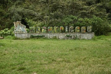 Machu Picchu taş tabelasının arkasında ağaçlar var. Aguas Calientes, Peru, 6 Ekim 2023. 