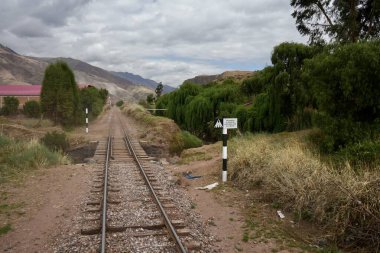 Arka planda dağlar olan raylar. Cusco, Peru, 8 Ekim 2023. 