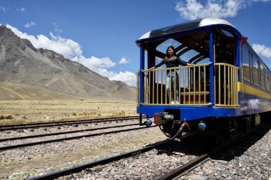 Mavi Perurail Titicaca Tren Gözlem aracı La Raya İstasyonu 'nda, 4319 metre yükseklikte, arkasında dağlar olan mavi gökyüzünün altında. La Raya, Cusco, Peru, 8 Ekim 2023. 