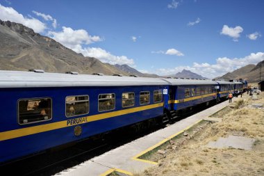 La Raya İstasyonu 'ndaki Mavi Perurail Treni. Mavi gökyüzünün altında, arkasında dağlar olan 4319 metre yükseklikte. La Raya, Cusco, Peru, 8 Ekim 2023. 