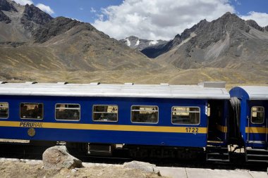 La Raya İstasyonu 'ndaki Mavi Perurail Treni. Mavi gökyüzünün altında, arkasında dağlar olan 4319 metre yükseklikte. La Raya, Cusco, Peru, 8 Ekim 2023. 