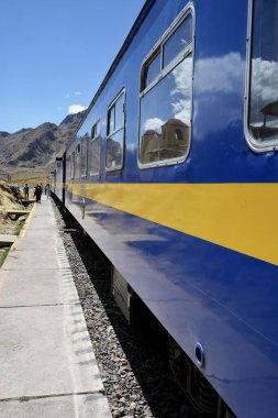 La Raya İstasyonu 'ndaki Mavi Perurail Treni. Mavi gökyüzünün altında, arkasında dağlar olan 4319 metre yükseklikte. La Raya, Cusco, Peru, 8 Ekim 2023. 