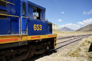 Mavi Perurail Motoru 653 La Raya İstasyonu 'nda, mavi gökyüzünün altında, arkasında dağlar olan 4319 metre yükseklikte. La Raya, Cusco, Peru, 8 Ekim 2023. 