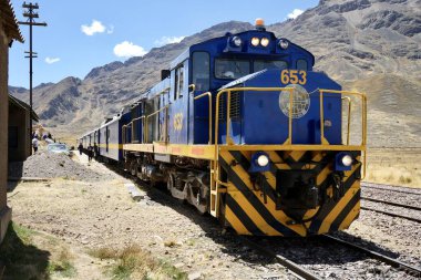 Mavi Perurail Motoru 653 La Raya İstasyonu 'nda, mavi gökyüzünün altında, arkasında dağlar olan 4319 metre yükseklikte. La Raya, Cusco, Peru, 8 Ekim 2023. 