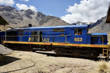 Mavi Perurail Motoru 653 La Raya İstasyonu 'nda, mavi gökyüzünün altında, arkasında dağlar olan 4319 metre yükseklikte. La Raya, Cusco, Peru, 8 Ekim 2023. 