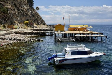 Titicaca Gölü 'nde arkasında plaj barı olan bir tekne. Isla del Sol, Bolivya, 9 Ekim 2023. 