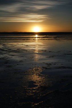 Uyuni Tuz Düzlüğü, Bolivya 'da Güneş Batışı, tuzlu suya yansıdı.