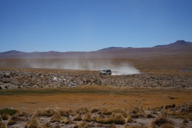 Bir Lexus 4x4 aracı Siloli Çölü 'nde, arkasında dağlar olan bir araç. Potosi, Bolivya, 13 Ekim 2023. 