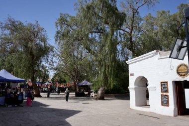 Ağaçlar ve beyaz binalarla dolu kasaba meydanı. San Pedro de Atacama, Şili. 15 Ekim 2023. 