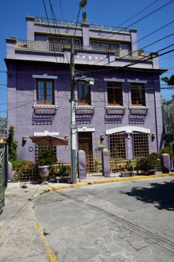 Striking purple front of the Hotel Manoir Atkinson in the sunshine. Valparaso, Chile, October 17, 2023.  clipart