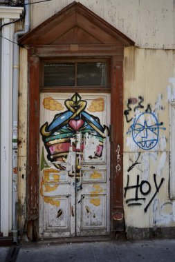 Grafiti ile renklendirilmiş ahşap bir kapı. Valparaso, Şili, 17 Ekim 2023. 