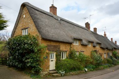 Bu güzel Oxfordshire Köyü 'ndeki güzel geleneksel Thatched kulübeleri. Wroxton, Oxfordshire, İngiltere. 7 Nisan 2024. 