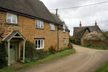 Bu güzel Oxfordshire Köyü 'ndeki güzel geleneksel Thatched kulübeleri. Wroxton, Oxfordshire, İngiltere. 7 Nisan 2024. 