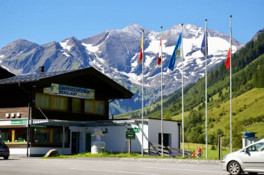 Grossglockner Yolu 'nun girişi arkasında bayraklar ve dağlar olan Grossglockner, Avusturya, 27 Temmuz 2009. 
