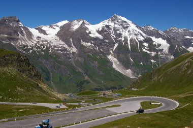 Arkasında karla kaplı dağlar olan yüksek kıvrımlı dağ yolu. Grossglockner, Avusturya, 27 Temmuz 2009. 