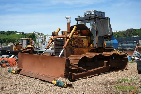 stock image Vintage rusty Komatsu digger on The Stade Beach under a blue sky. Hastings, England, UK. May 17, 2024. 