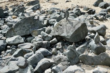 Cornish sahilinde kayaların üzerinde dengelenmiş taşlar.. 