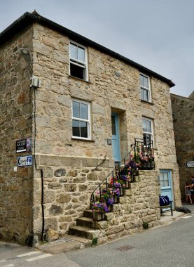 Tipik 20. yüzyıl başlarında taş basamakları çiçek kaplı taş ev. St Ives, Cornwall, İngiltere, İngiltere. 19 Temmuz 2024. 