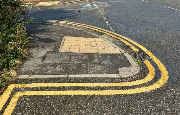 stock image Double Yellow Lines pained at an unusual angle round a corner. England, UK. August 12, 2024. 