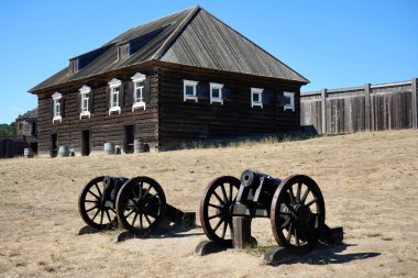 Fort Ross yerleşim yerindeki tarihi ahşap binanın dışında klasik toplar. Fort Ross, Kaliforniya, ABD. Eylül 2024. 