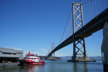 San Francisco Fire Department Fireboat 3 moored at The Fire Station with Oakland Bay Bridge behind. San Francisco, California, USA. September 2024.  clipart