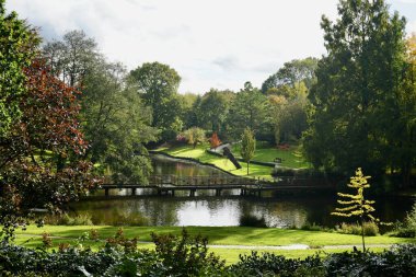 Leeds Kalesi, Maidstone, İngiltere 'de yaya köprüsü ile çevrili çağlayan bahçe. Ekim 2024. 