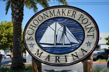 Sign for Schoonmaker Point Marina with palm tree behind, Sausalito, California, USA. September 2024.  clipart