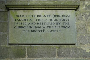 Köy okulundaki taş tabelada Charlotte Bronte yazıyor. Haworth, Keighley BD22, İngiltere. Kasım 2024. 