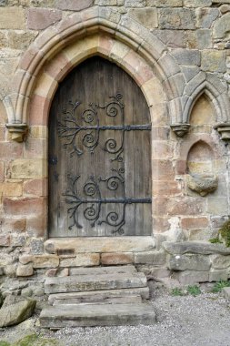 Bolton Manastır Kilisesi 'nde demirden menteşeleri olan antik ahşap kapı. Bolton Abbey, Skipton, İngiltere, İngiltere. Mart 2025. 