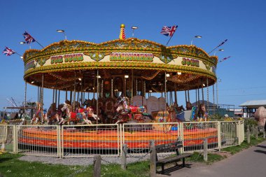 Geleneksel bir atlıkarınca sahilde dolaşır, Paignton, Devon, İngiltere, İngiltere. Mayıs 2025. 