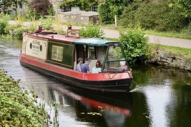 Leeds ve Liverpool Kanalı 'nda Salts Mill' e yakın bir turist teknesi. Saltaire, Shipley, İngiltere, İngiltere. Ağustos 2025. 