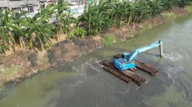 Şehirde bir teknede çalışan bir adamın hava görüntüsü.