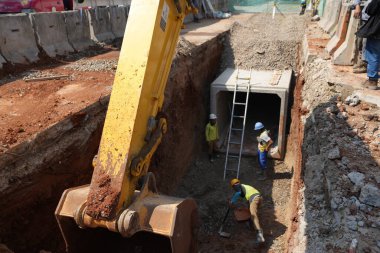İnşaat işçileri inşaat sahasına beton döşüyorlar.