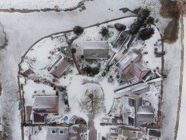 Soğuk bir kış sabahı Hollanda 'nın Frizya şehri Sneek' te insansız hava aracı görüntüsü. Evler ve sokaklar beyaz karla kaplı, kanallar ve su buzla kaplı..