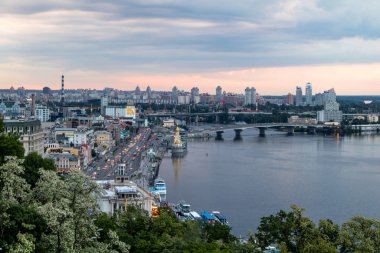 Volodymyr Hill Park Kiev 'deki Dinyeper nehrinin günbatımı manzarası. Yüksek kalite fotoğraf. Dramatik bir gökyüzü ve aşağıdaki trafik nehri ve kıyılarını kareler..