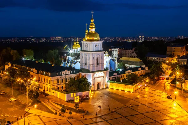 Aziz Michaels Altın Kubbe Manastırı, Kiev Ukrayna. Yüksek kaliteli fotoğraf, mavi saat alacakaranlıklarında dramatik bulutlu bir gökyüzü ve manastırın önündeki meydanın önündeki fenerlerden gelen altın bir ışık.