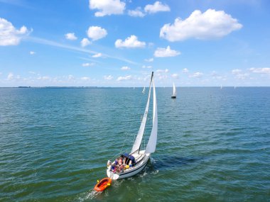 Hollanda 'daki bir gölde, tipik bir Hollanda mavisi gökyüzü altında yelkenlilerin insansız hava aracı görüntüleri. Yüksek kalite fotoğraf