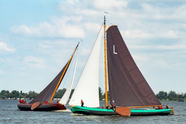 Geleneksel yelkenli tekneleri Sneekermeer, Friesland 'da yarışıyor. Tahta, düz tabanlı, Skutsjes adında tarihi yelkenliler Sneek yakınlarındaki bir Frisian gölünde yarışıyorlar. Yüksek kalite fotoğraf