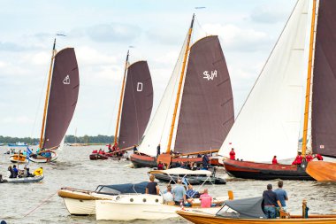 Geleneksel yelkenli tekneleri Sneekermeer, Friesland 'da yarışıyor. Tahta, düz tabanlı, Skutsjes adında tarihi yelkenliler Sneek yakınlarındaki bir Frisian gölünde yarışıyorlar. Yüksek kalite fotoğraf