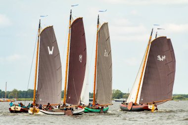 Geleneksel yelkenli tekneleri Sneekermeer, Friesland 'da yarışıyor. Tahta, düz tabanlı, Skutsjes adında tarihi yelkenliler Sneek yakınlarındaki bir Frisian gölünde yarışıyorlar. Yüksek kalite fotoğraf
