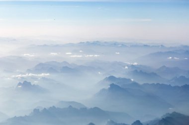Aerial view of morning sunlight on Summer Alps. A little snow on the tops, cascading silhouette of mountain ranges. Soft morning sunlight . High quality photo