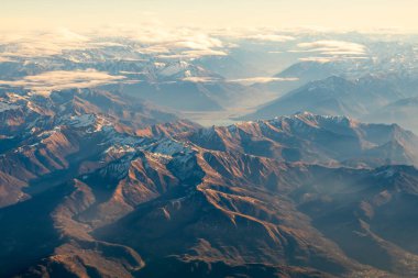 Morning sunlight on Summer Alps. A little snow on the tops, cascading silhouette of mountain ranges. Soft morning sunlight . High quality photo