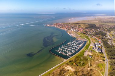 Aerial drone image of Terschelling and the Wadden sea on a summer day. Low tide shows the sandbanks and shallows of the Wadden sea. Marina and West-Terschelling and dunes visible. High quality photo clipart