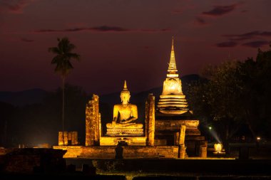 Tayland 'daki Sukhothai Tarihi Parkı' ndaki antik tapınaklar. Tarihi kırmızı tuğla yapılar ve tapınaklar. Siluet turuncu günbatımı gökyüzüne karşı. Renkli ve enerjik. İnsan yok. Yüksek kalite fotoğraf