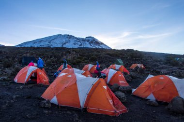 Kilimanjaro Dağı 'nda sabah güneşiyle aydınlanan turuncu çadırlar. Yüksek kalite fotoğraf