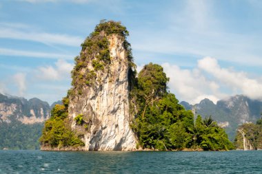 Khao Sok Ulusal Parkı, Tayland 'daki yeşil ormanlarla kaplı kireçtaşı uçurumları. Mavi göl ve uzun kuyruk teknesi, mavi gökyüzü. Yüksek kalite fotoğraf