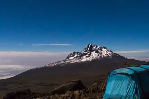 Blue tent pitched on gravel on Mount Kilimanjaro, via of Mount Meru and stars. High quality photo